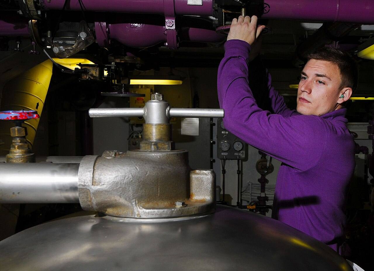 US Navy 110330-N-7488A-031 Aviation Boatswain's Mate (Fuel) Airman Jesse Malm opens an inlet to a fuel purifier in JP-5 pump room No. 2