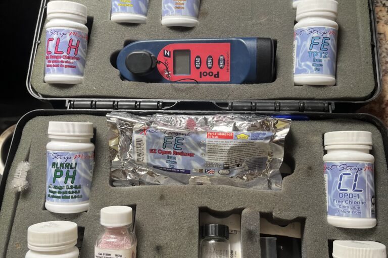 A home water test kit with labeled reagent bottles in a carrying case